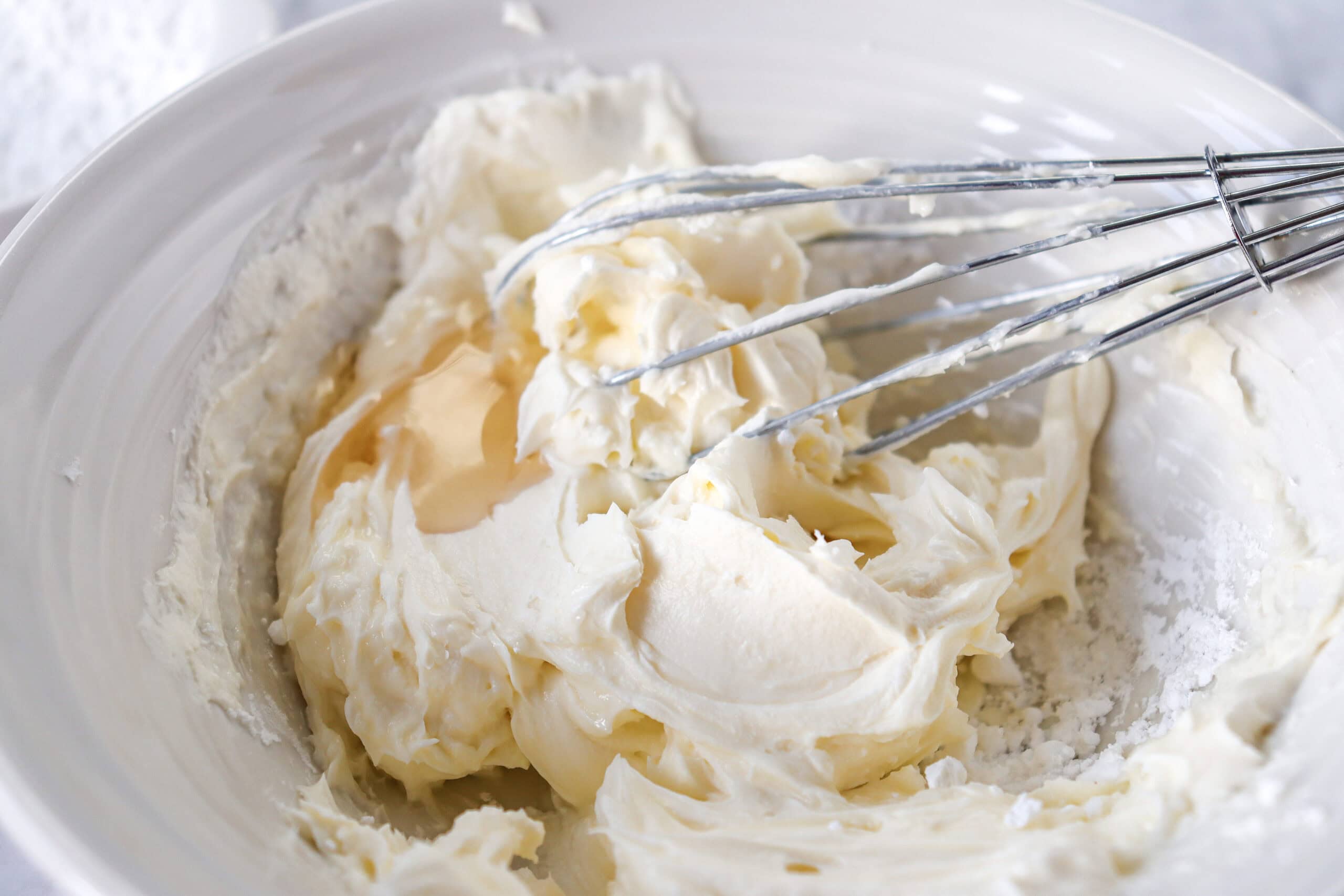 Close-up of glaze ingredients in a bowl with a whisk.