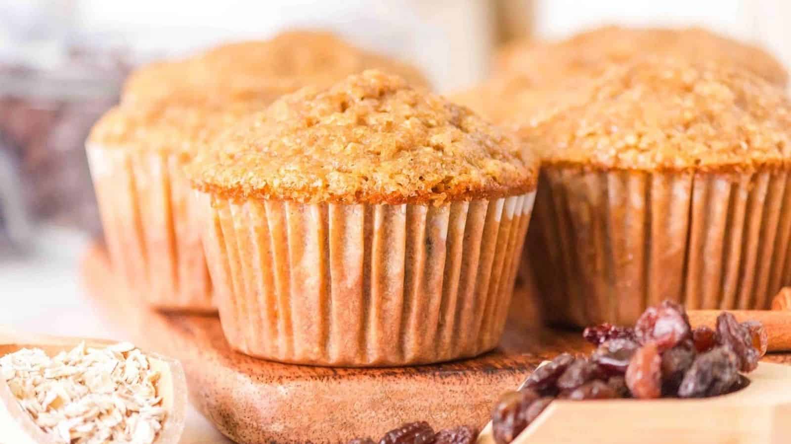 Close-up image of oatmeal raisin muffins on a wooden board.