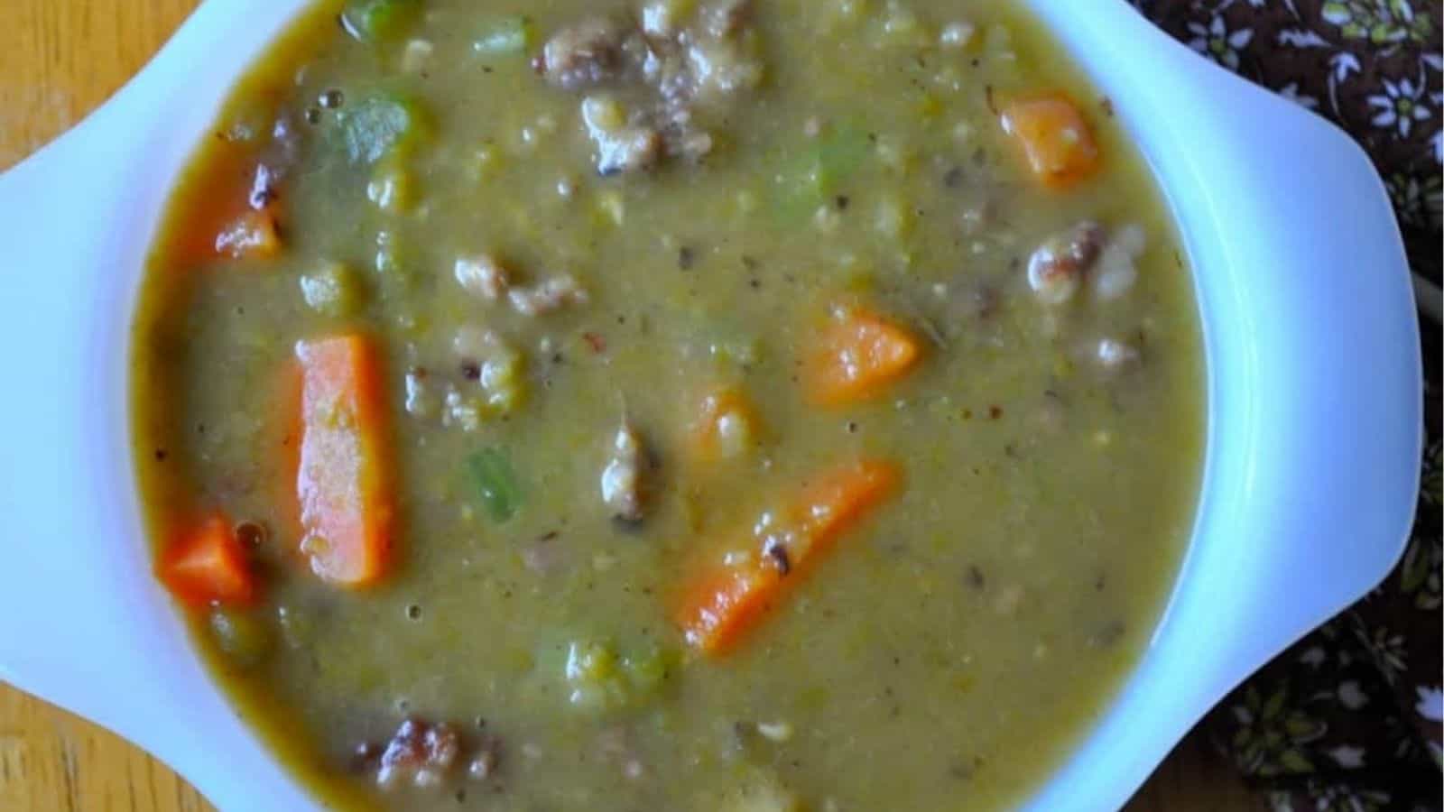 Top view of slow cooker split pea soup with sausage in a bowl.