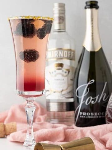 A glass of Sparkling Meyer Lemon Blackberry Jam Prosecco Cocktail.