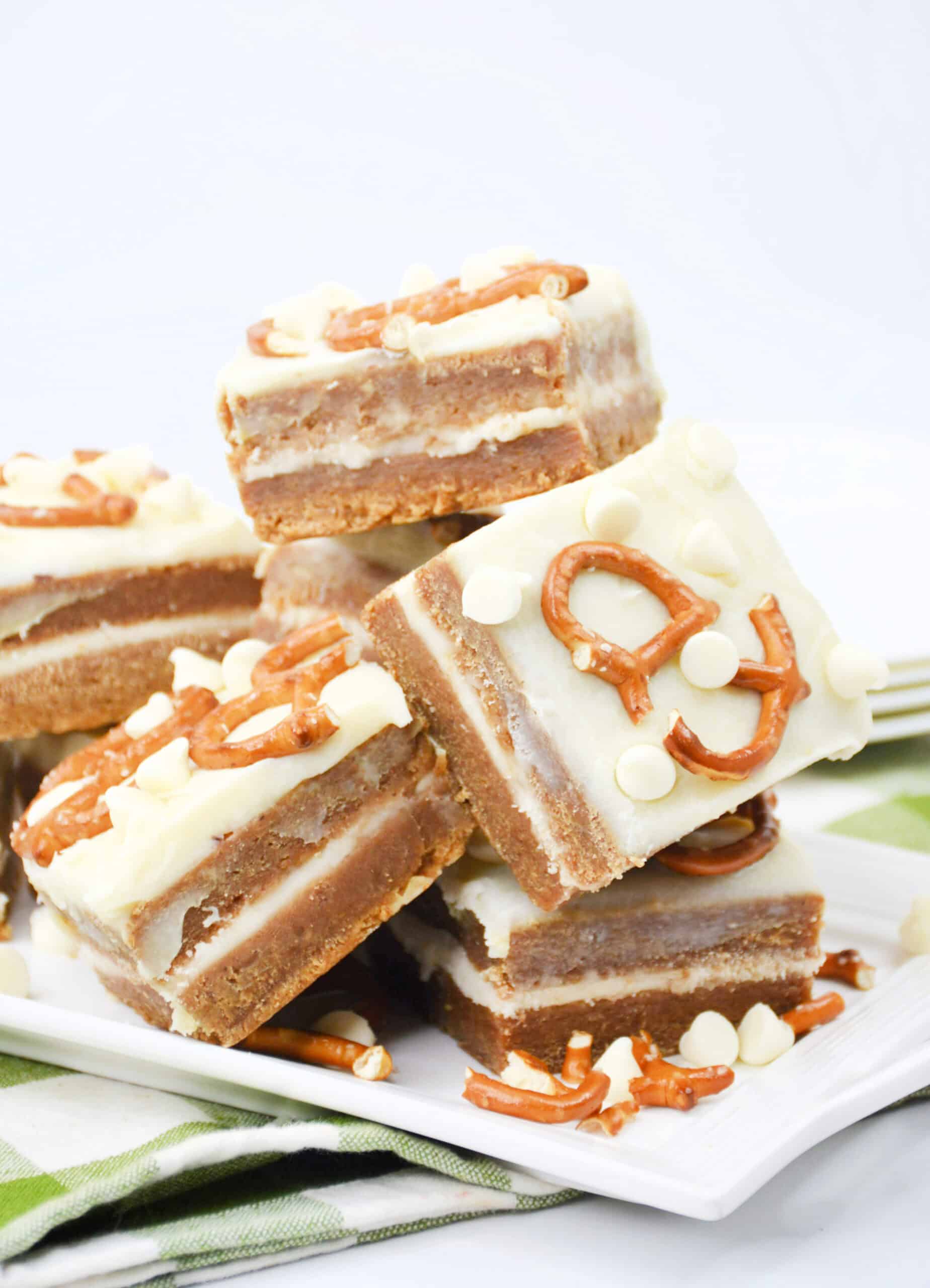 Close-up image of a batch of cooked White Chocolate Pretzel Pumpkin Blondies arranged on a tray.