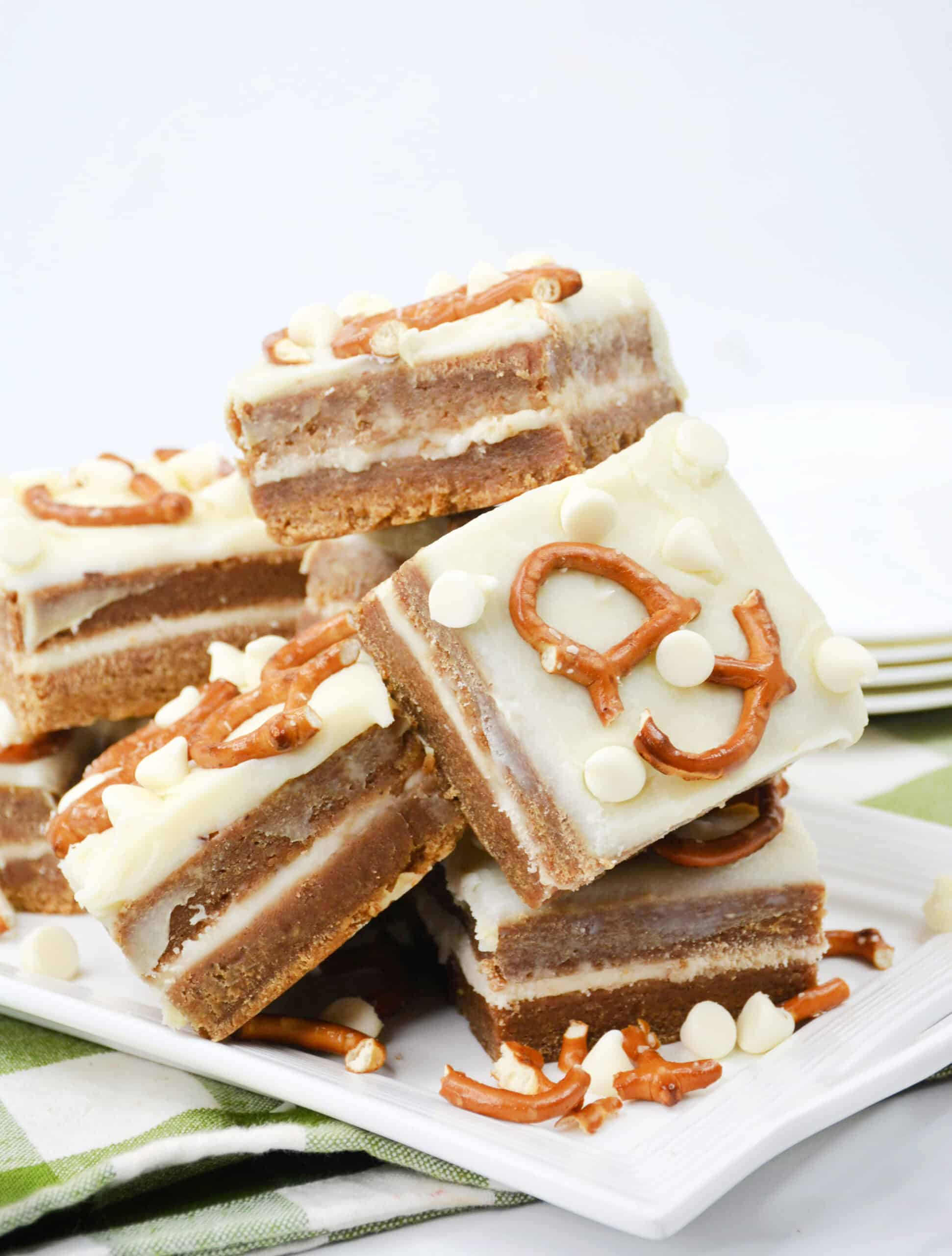 Close-up image of a batch of cooked White Chocolate Pretzel Pumpkin Blondies arranged on a tray.