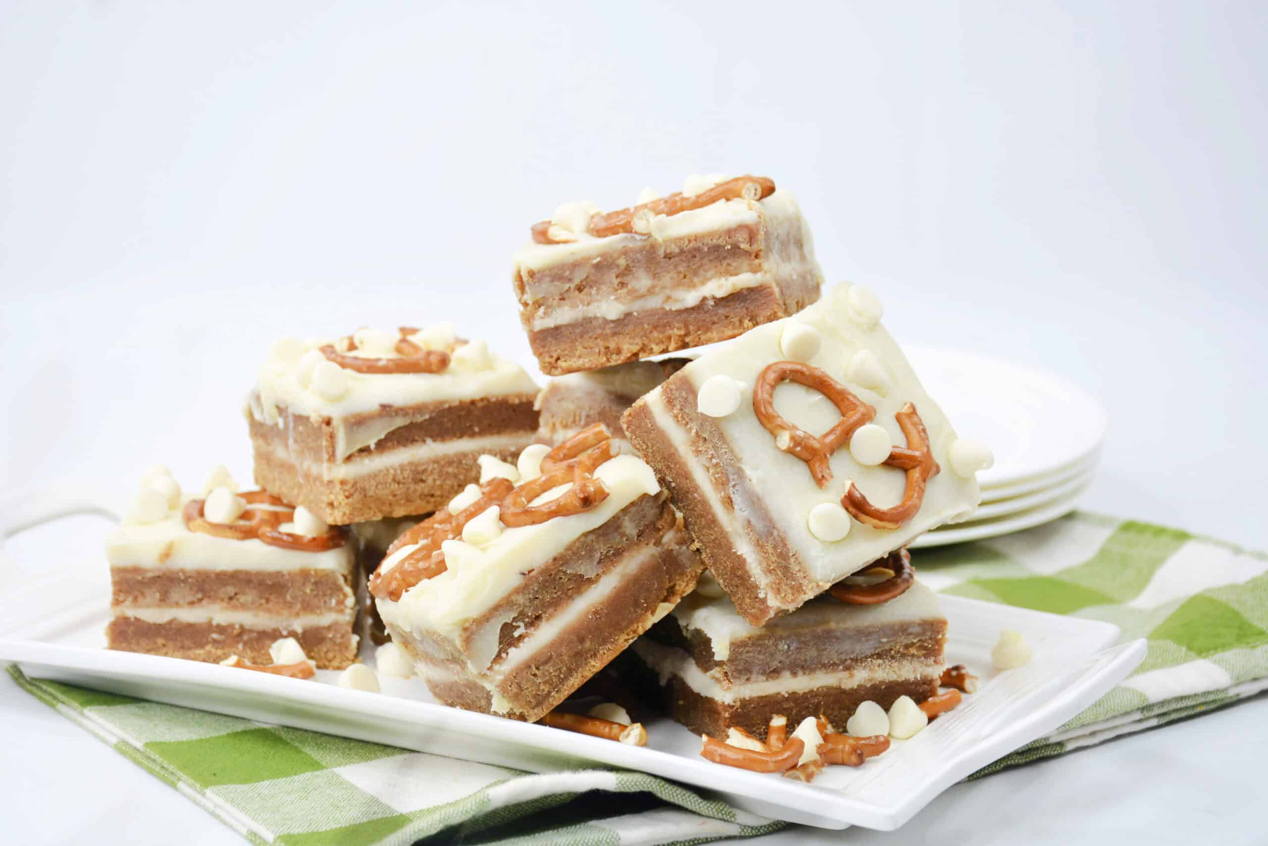 Close-up image of a batch of cooked White Chocolate Pretzel Pumpkin Blondies arranged on a tray.