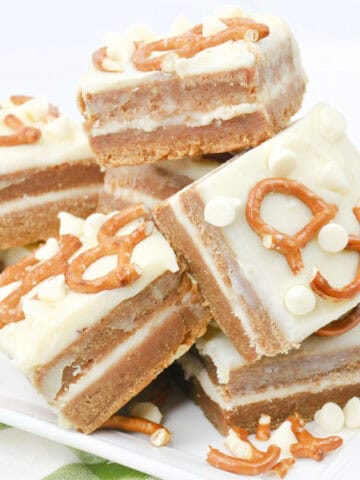 Close-up image of a batch of cooked White Chocolate Pretzel Pumpkin Blondies arranged on a tray.