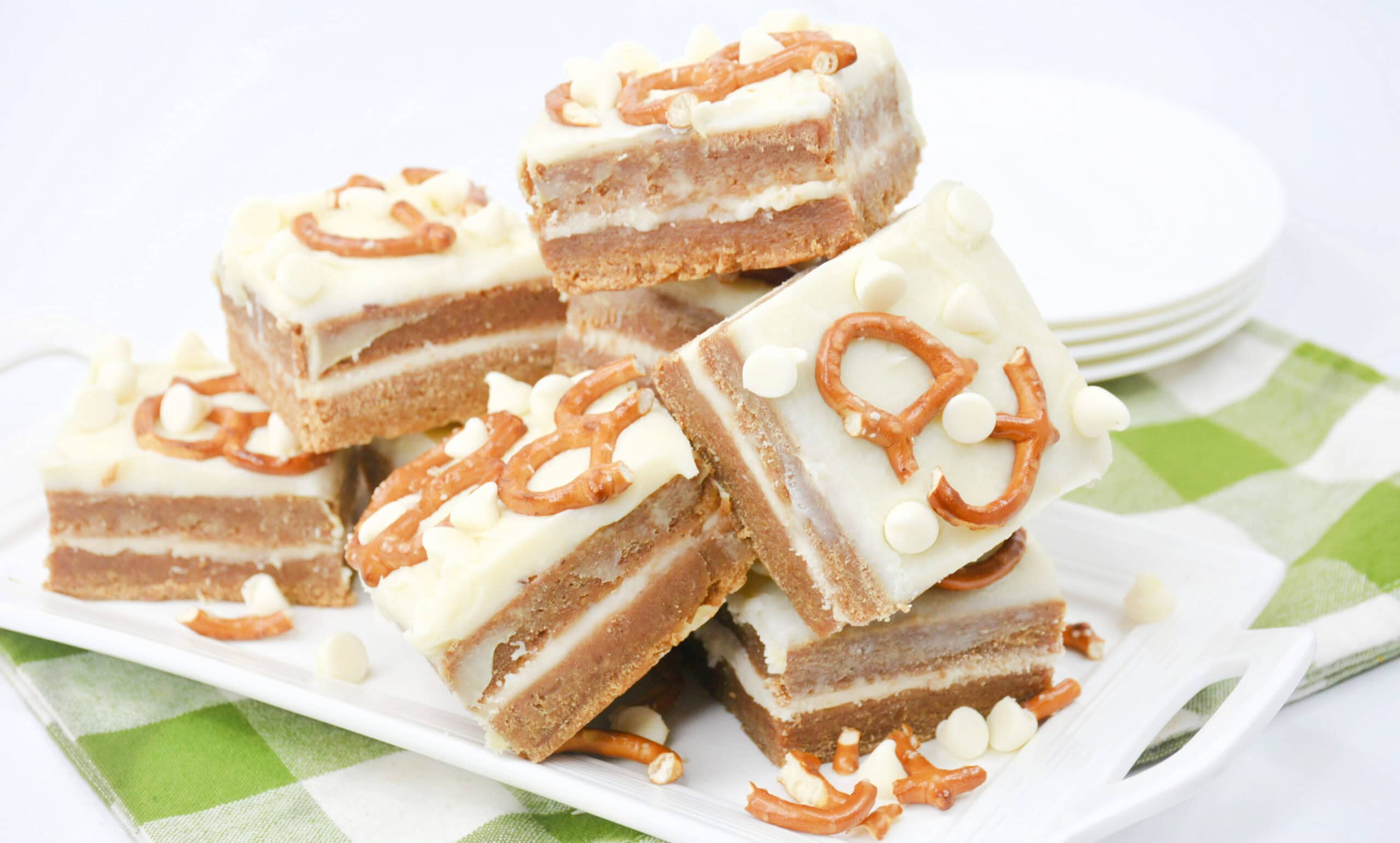 Close-up image of a batch of cooked White Chocolate Pretzel Pumpkin Blondies arranged on a tray.