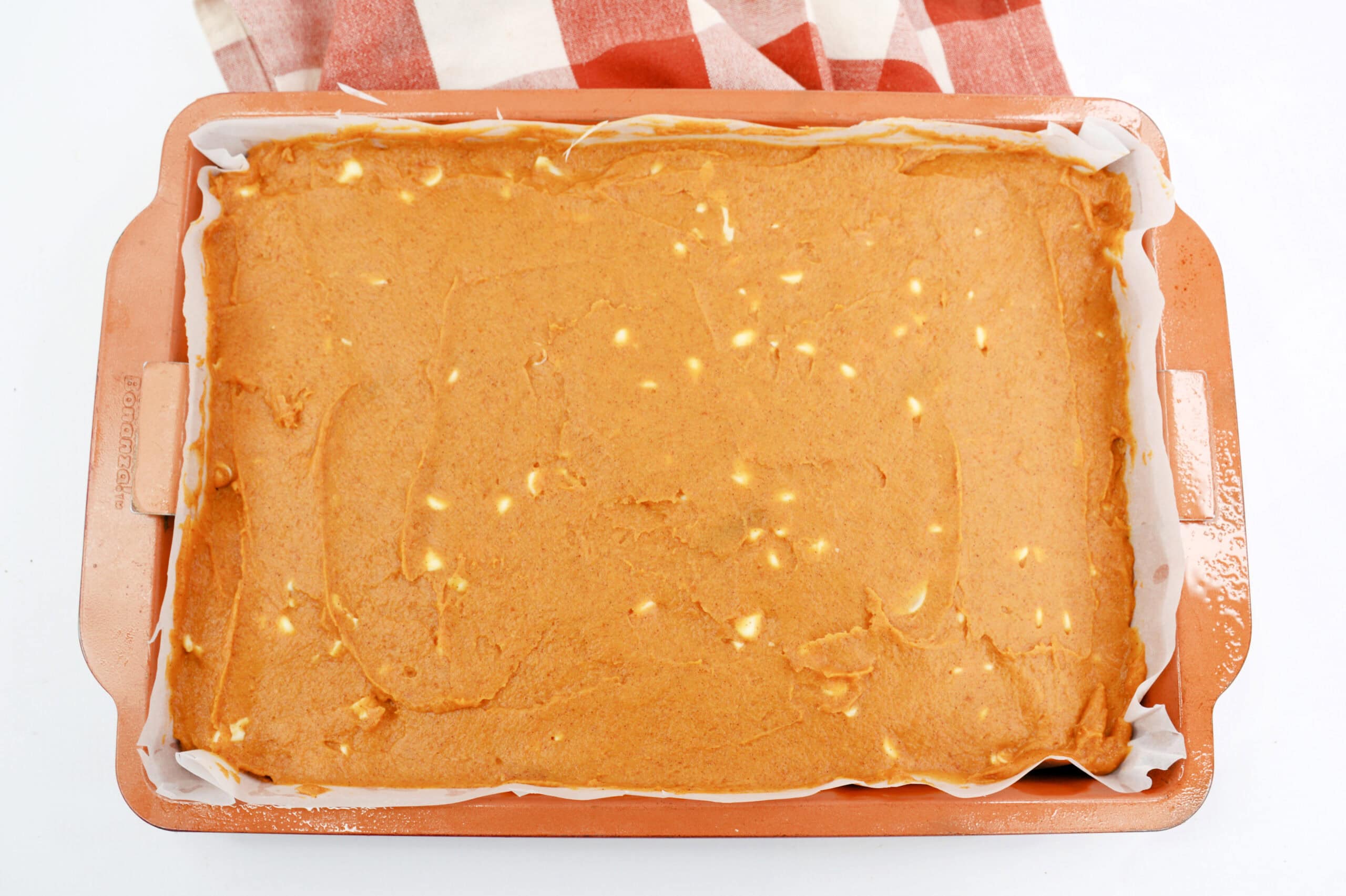 Overhead image of pumpkin blondies batter spread evenly in a baking pan.