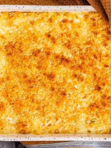Top view of cheesy asparagus casserole on a wooden board.