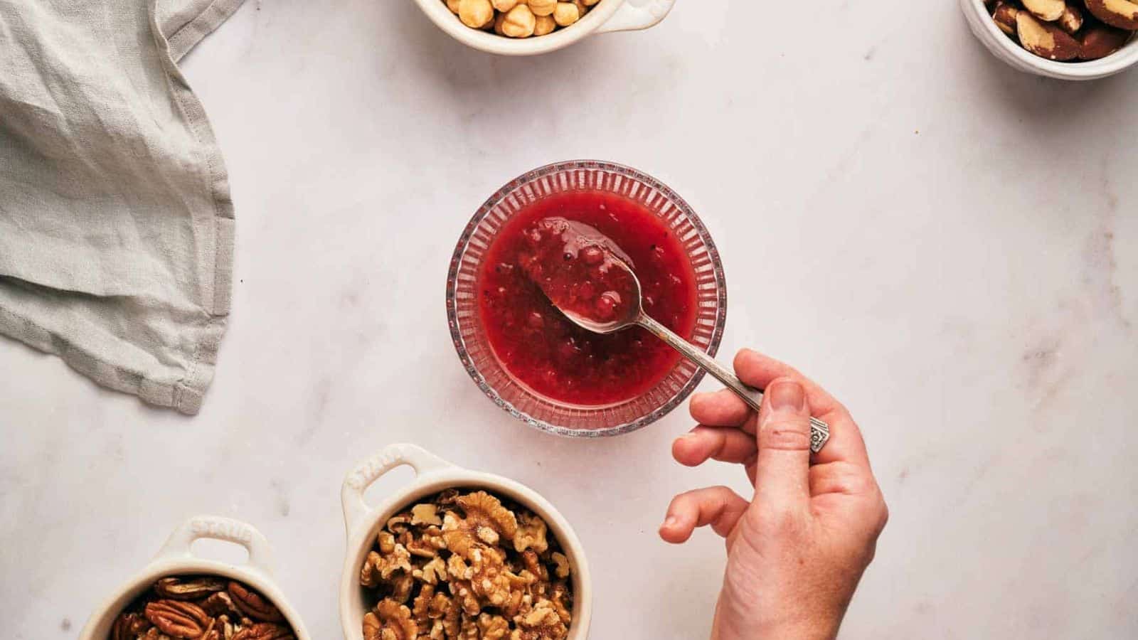 Someone scooping a spoonful of cranberry sauce.