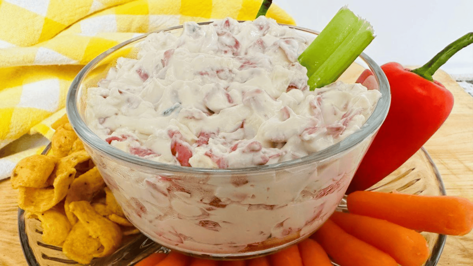 A bowl of dip with carrots and celery.