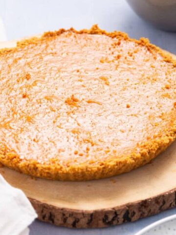 Whole Pumpkin Pie with Condensed Milk on a wooden board.
