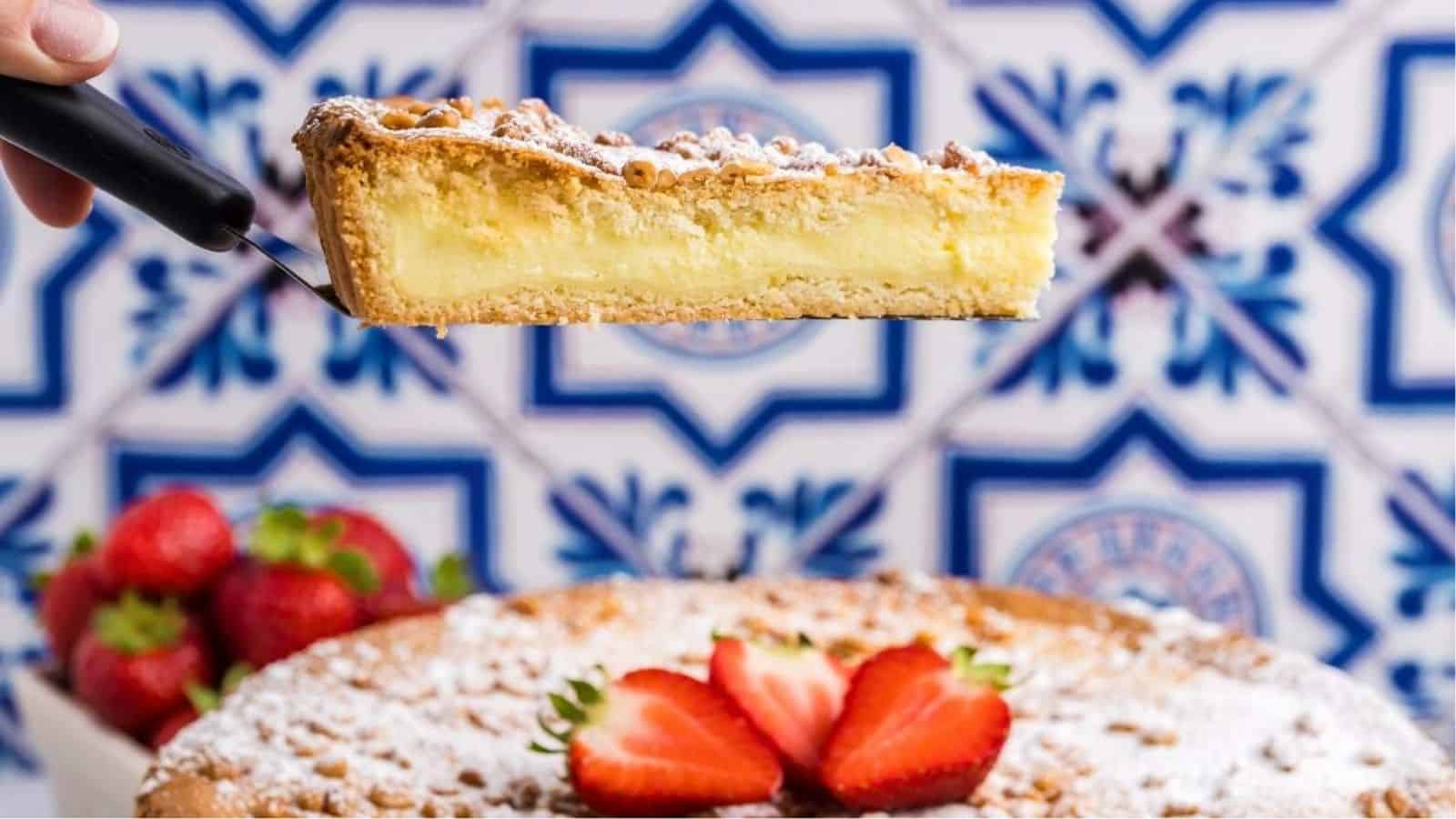 A slice of torta della nonna being lifted.