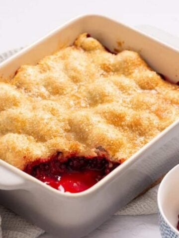 An image blackberry cobbler with pie crust in a baking dish.