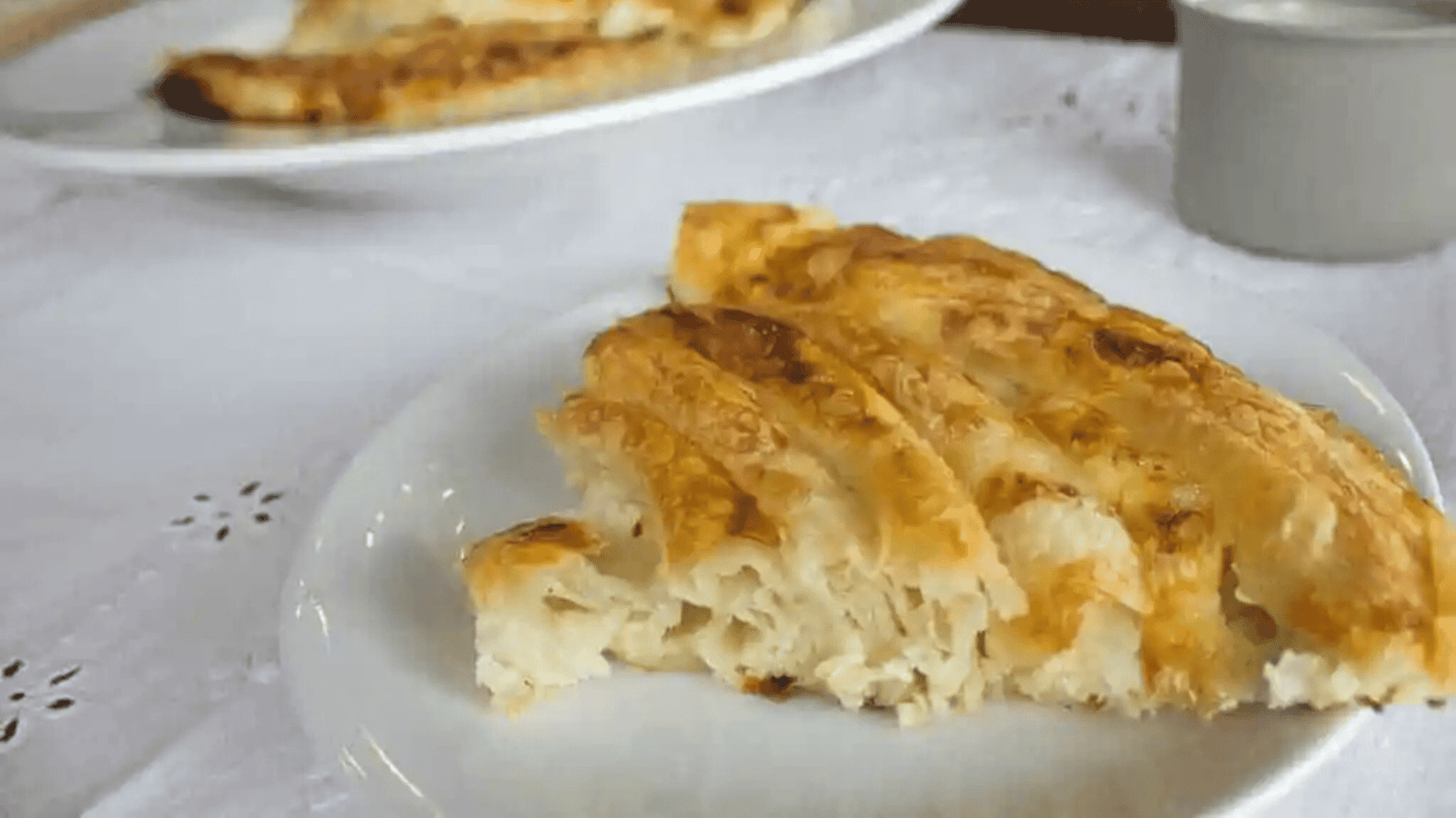 Cheesy cinnamon rolls in a white baking dish.