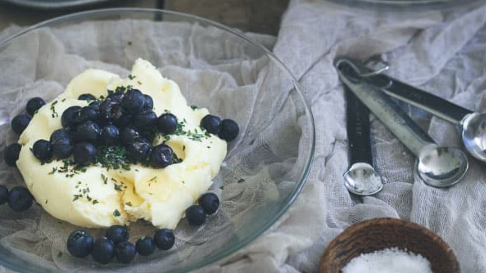 Homemade blueberry lavender honey butter on a glass plate.