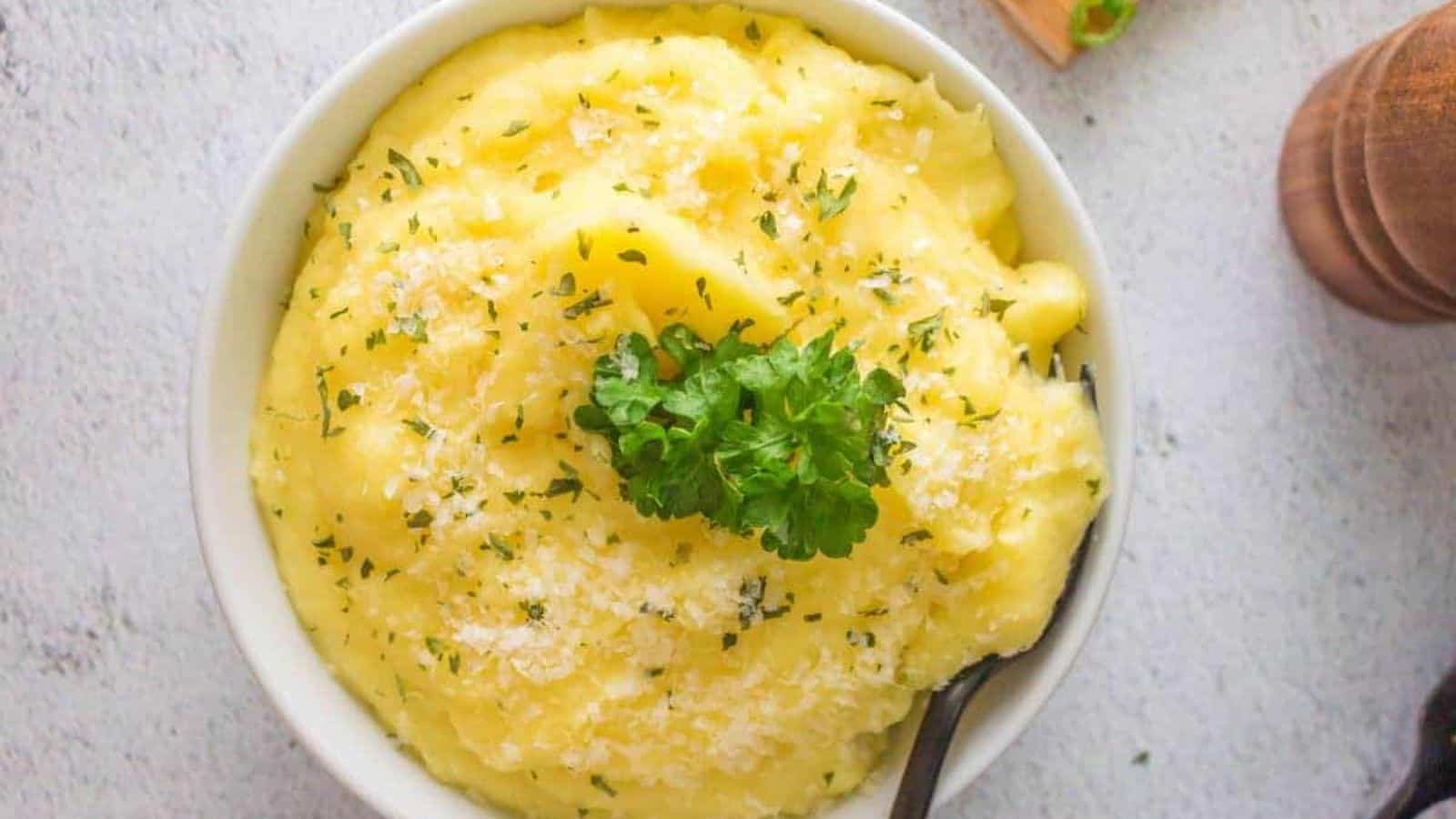 Top view of a bowl of Ninja Foodi Mashed Potatoes with some garnish on top.