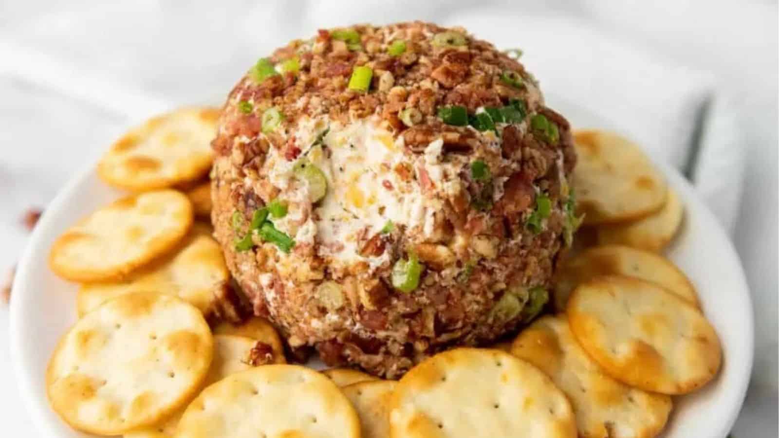 Close-up image of pecan bacon cheeseball with biscuits on a plate.