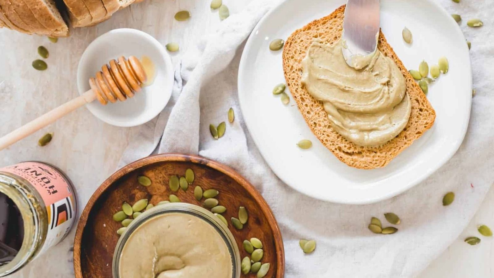 Overhead image of pumpkin seed butter being spread on a bread.