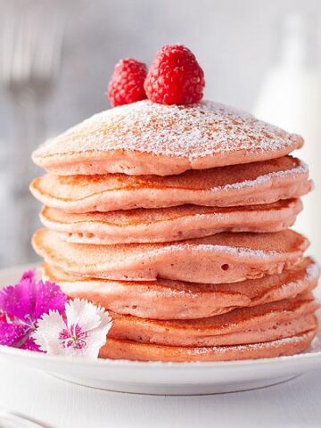 A stack of Beetroot Light and Fluffy Pink Pancakes on a plate.