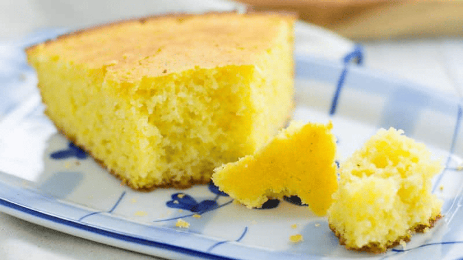 Overhead shot of cornbread in a cast iron skillet with a single slice cut out.
