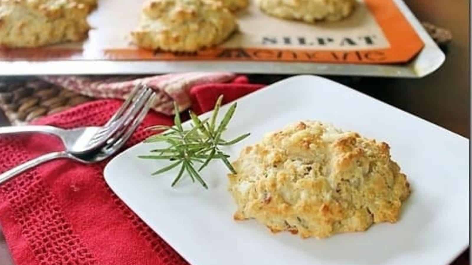 Close-up image of rustic rosemary cheddar bacon biscuit on a plate.