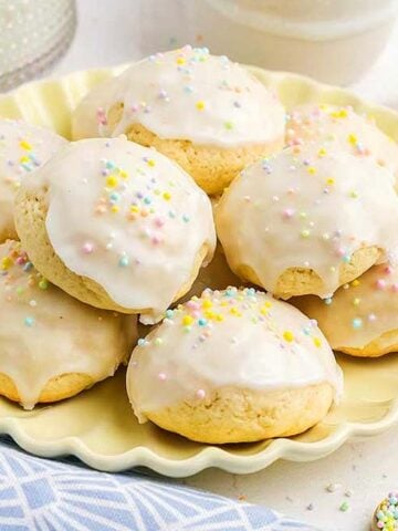 A stack of Italian Easter Cookies on a yellow plate.