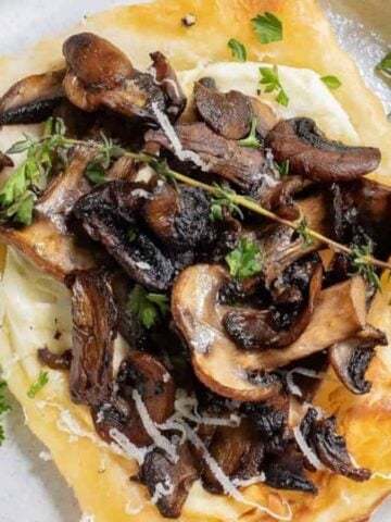 A close up image of a single mushroom tartlet on a serving plate.