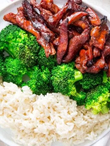A plate of Chinese Boneless Spare Ribs with some broccoli and rice.