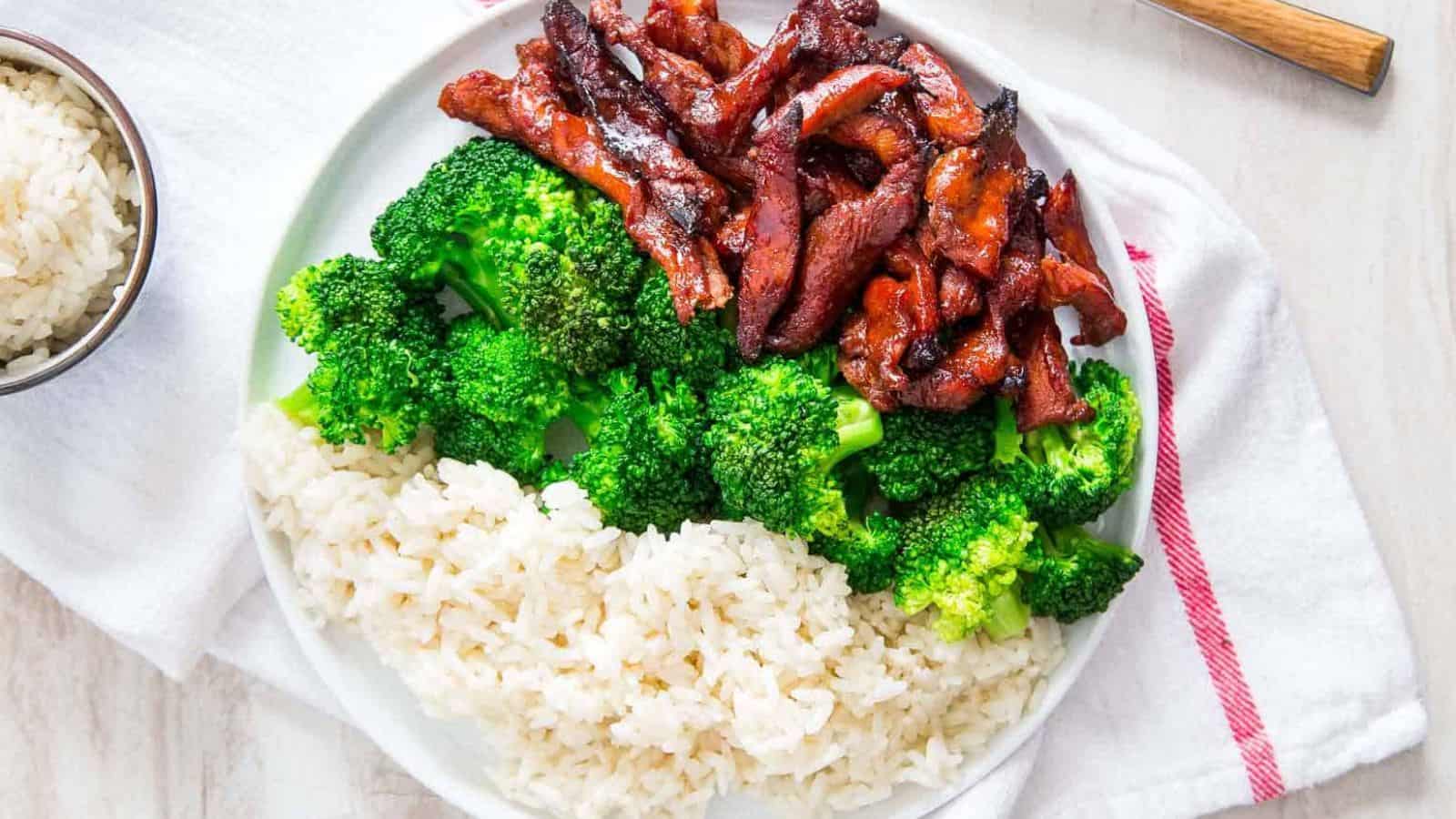 A plate of Chinese Boneless Spare Ribs with some broccoli and rice.