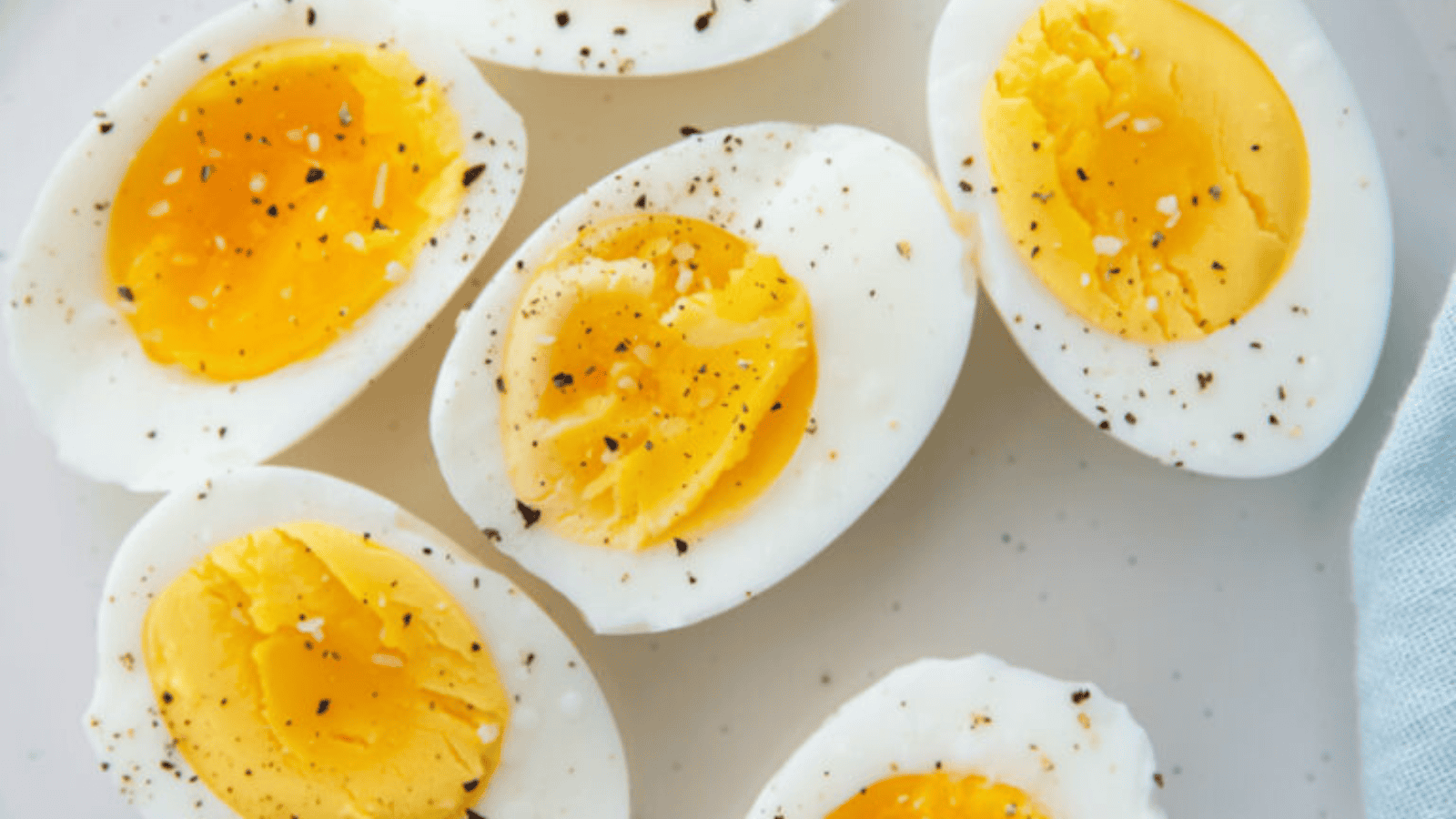 Pefected Air Frer Boiled Eggs with sallt and pepper on a white plate.