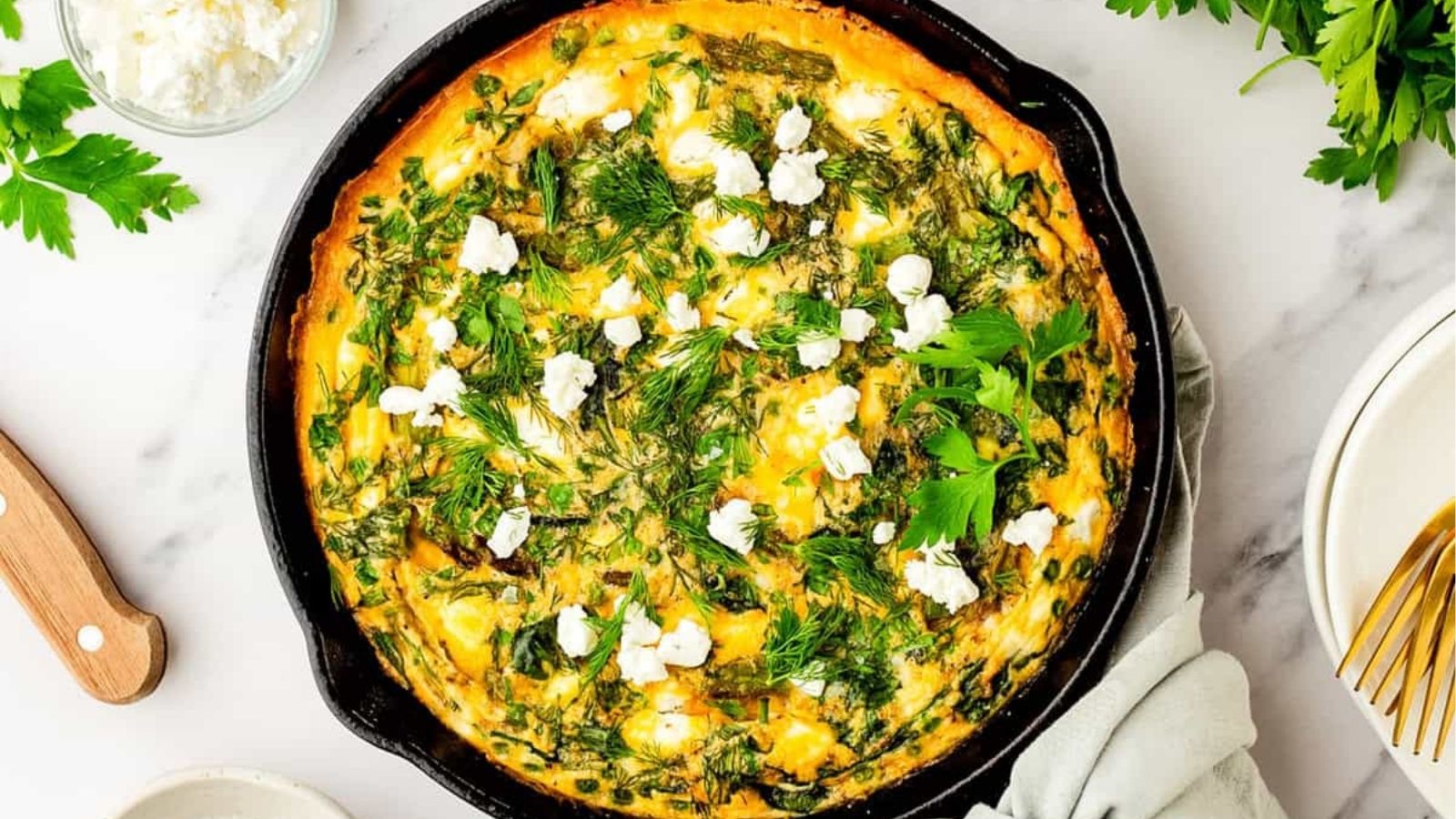 An overhead image of asparagus frittata in a cast iron skillet.