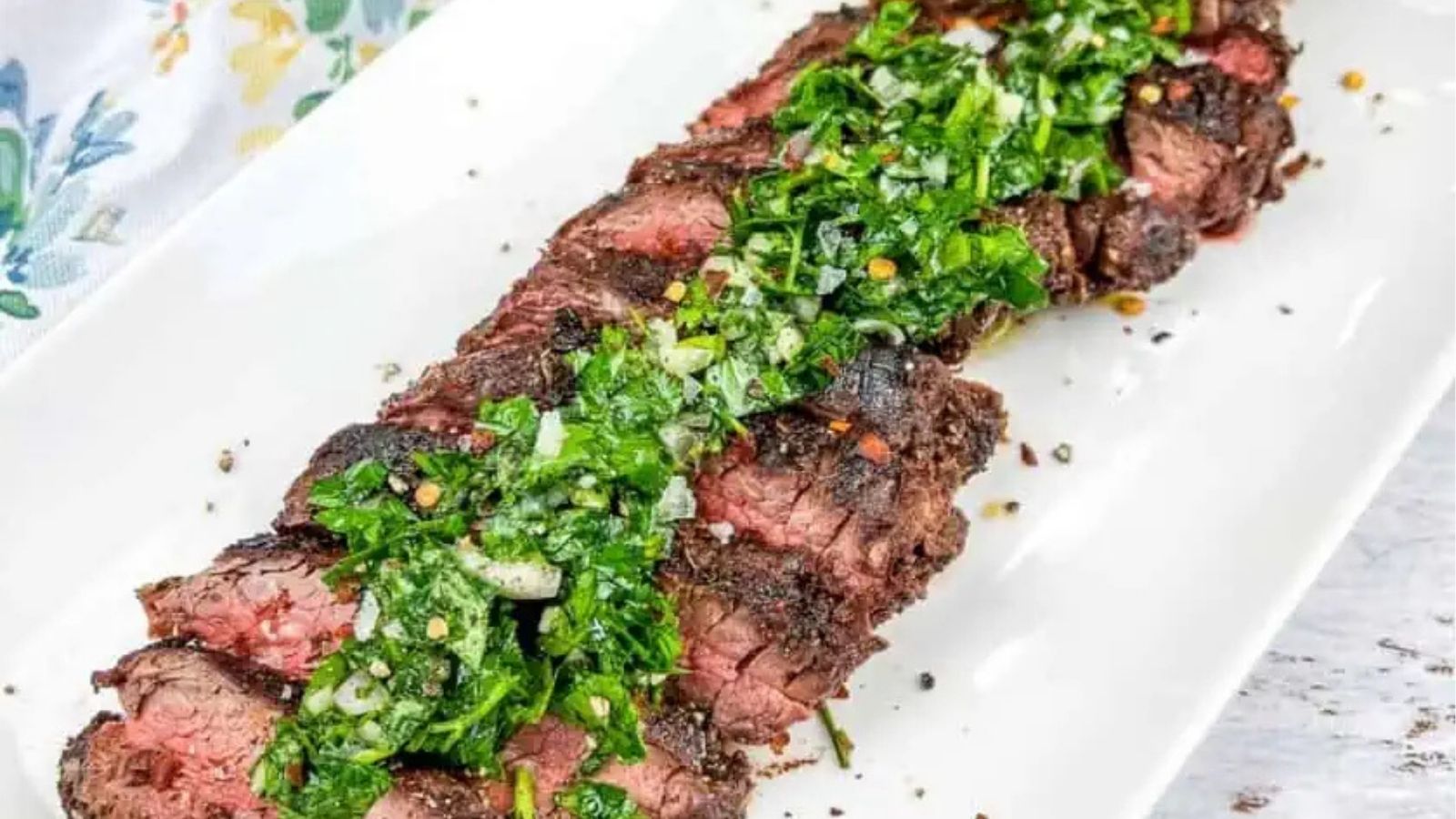 Close-up image of chimichurri sauce on top of grilled meat.