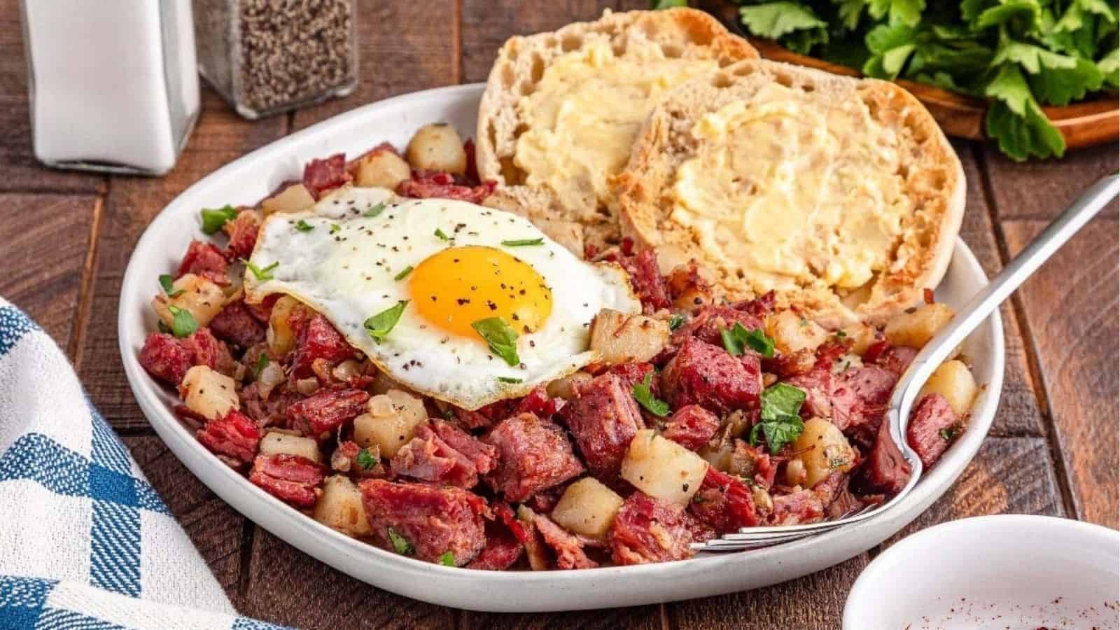 Close-up image of corned beef hash topped with egg on a plate.