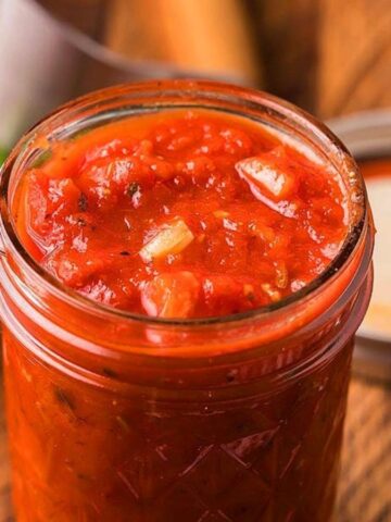Close-up image of Italian garlic marinara sauce in a jar.
