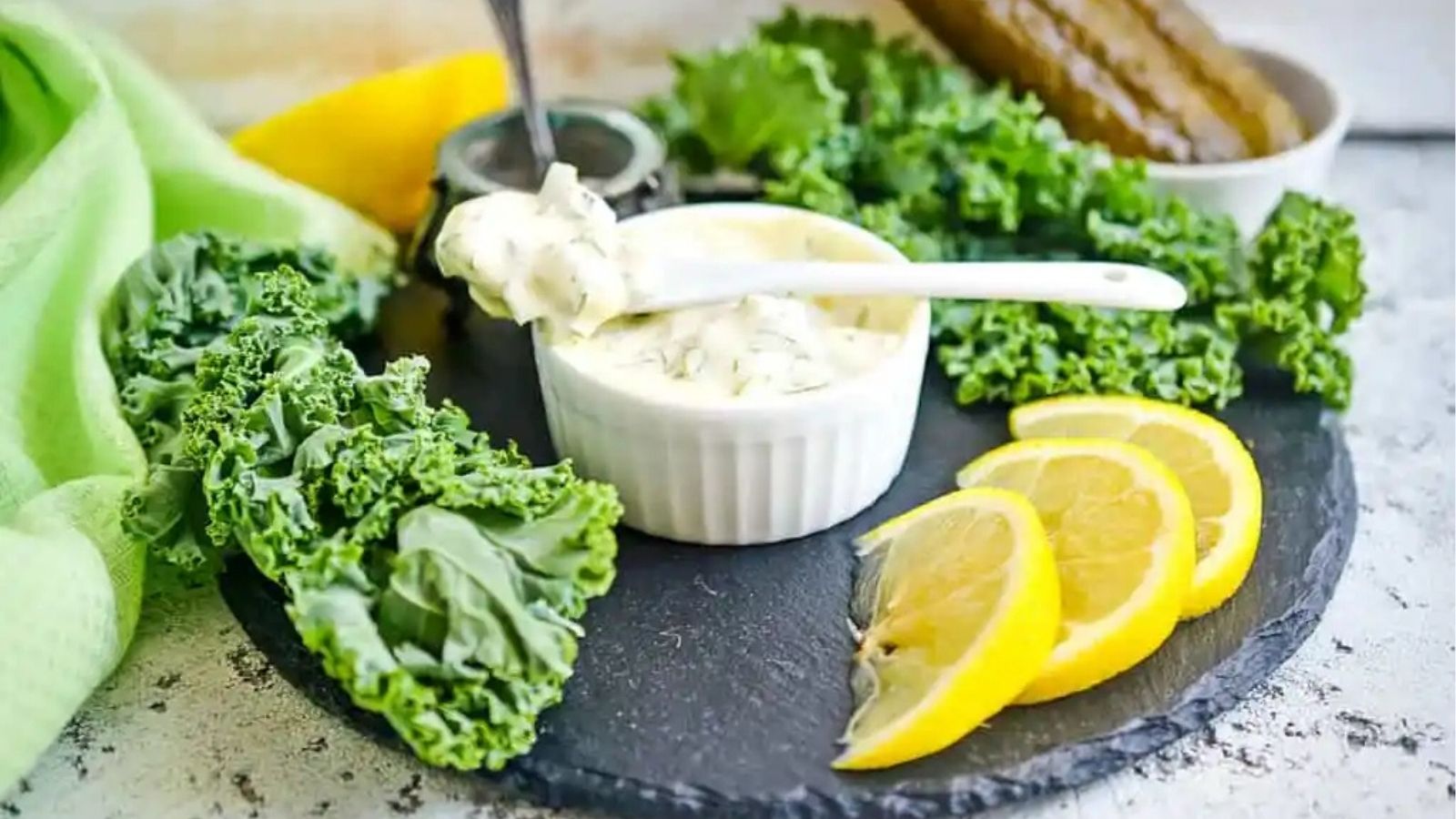 Close-up image of a spoonful keto tartar sauce on top of a bowl.