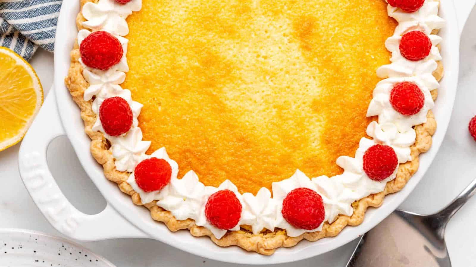 A slice of lemon pie with raspberries on top.