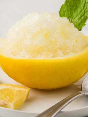 One Lemon Granita on a plate with a spoon.