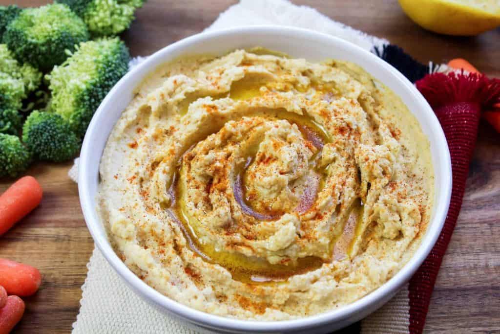 A bowl of hummus swirled with olive oil and spices on top