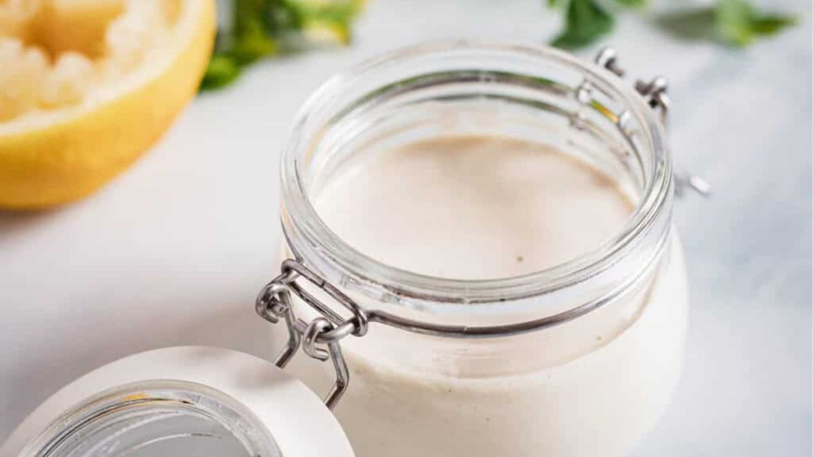 Close-up image of Tahini sauce in a jar.