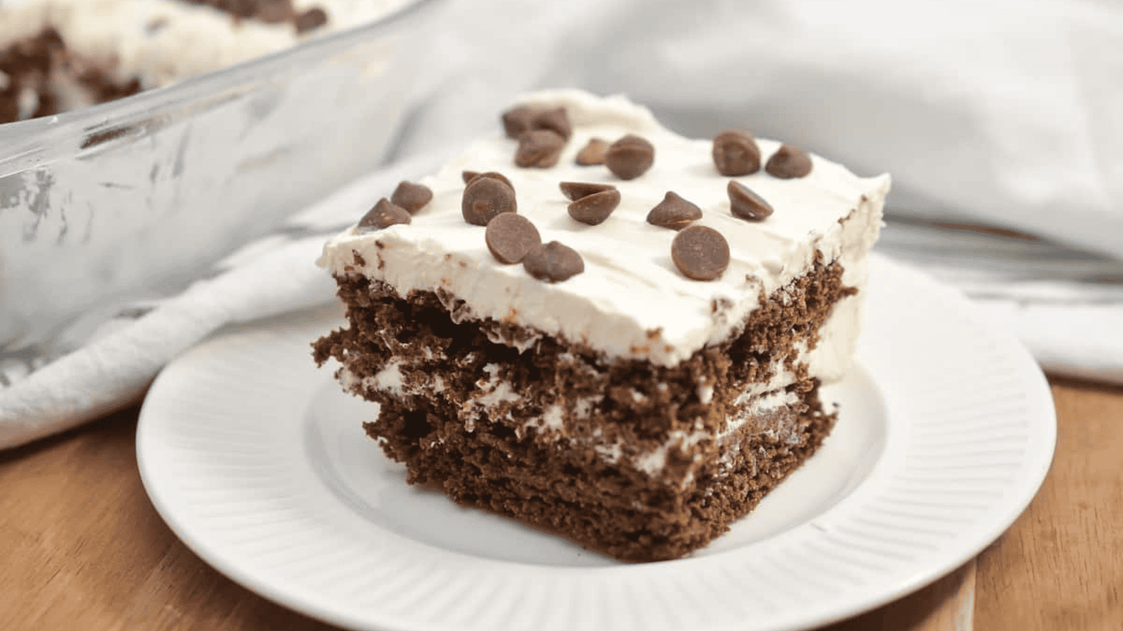 A slice of chocolate cake on a white plate.