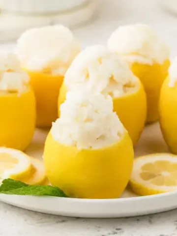 A plate with lemons full of Lemon Sorbet.