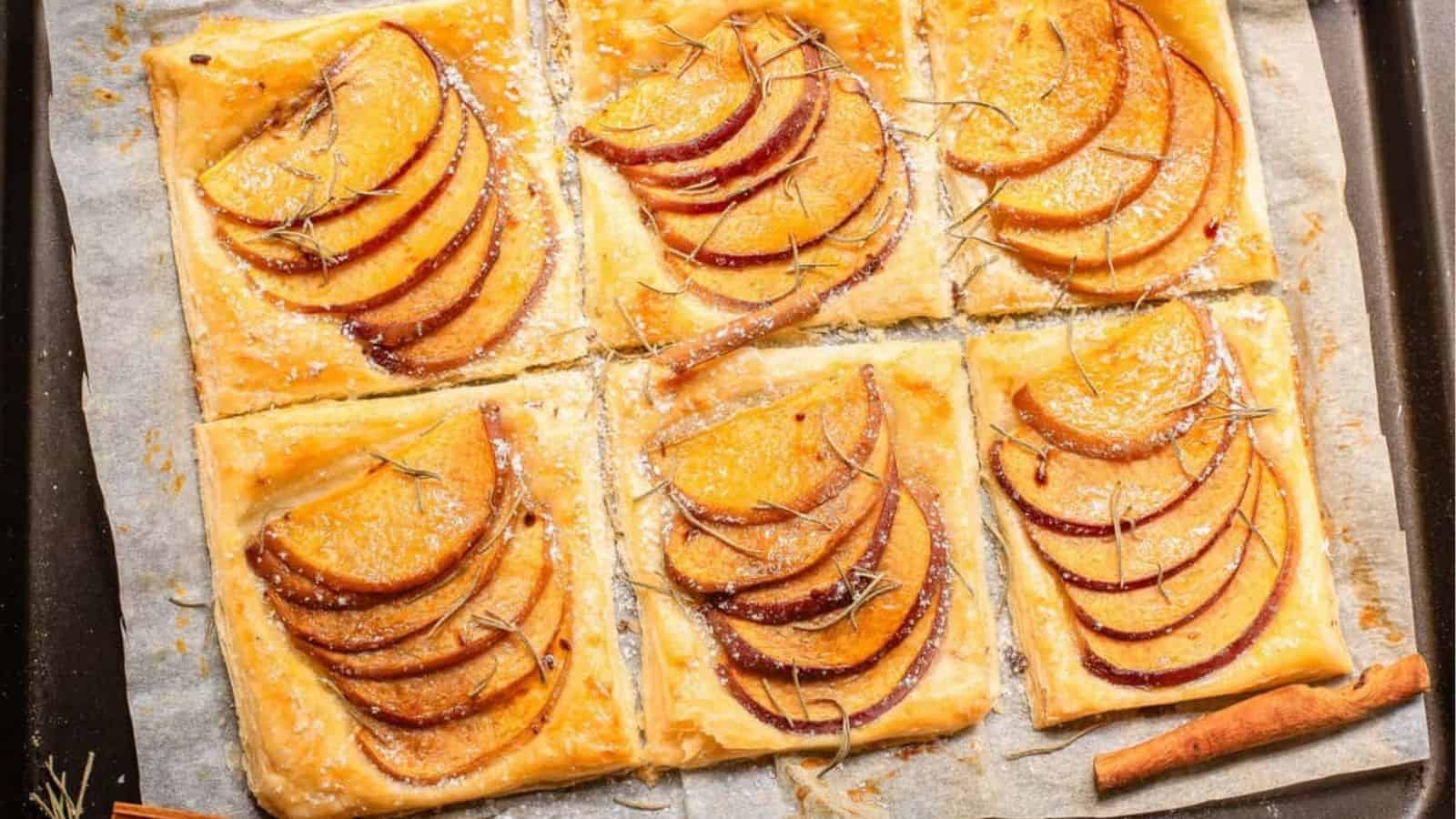 An overhead image of peach puff pastries on a parchment sheet.