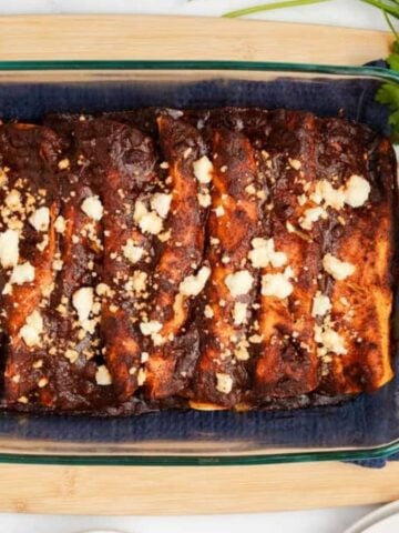 An overhead image of black bean enchiladas in a baking dish.