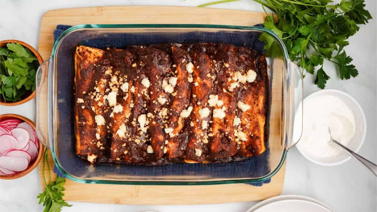 An overhead image of black bean enchiladas in a baking dish.