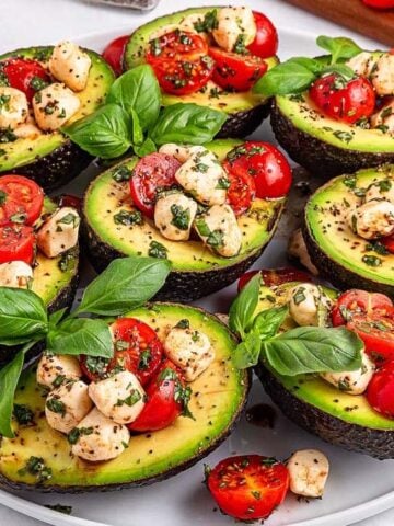 Eight Caprese Stuffed Avocado on a wide plate.