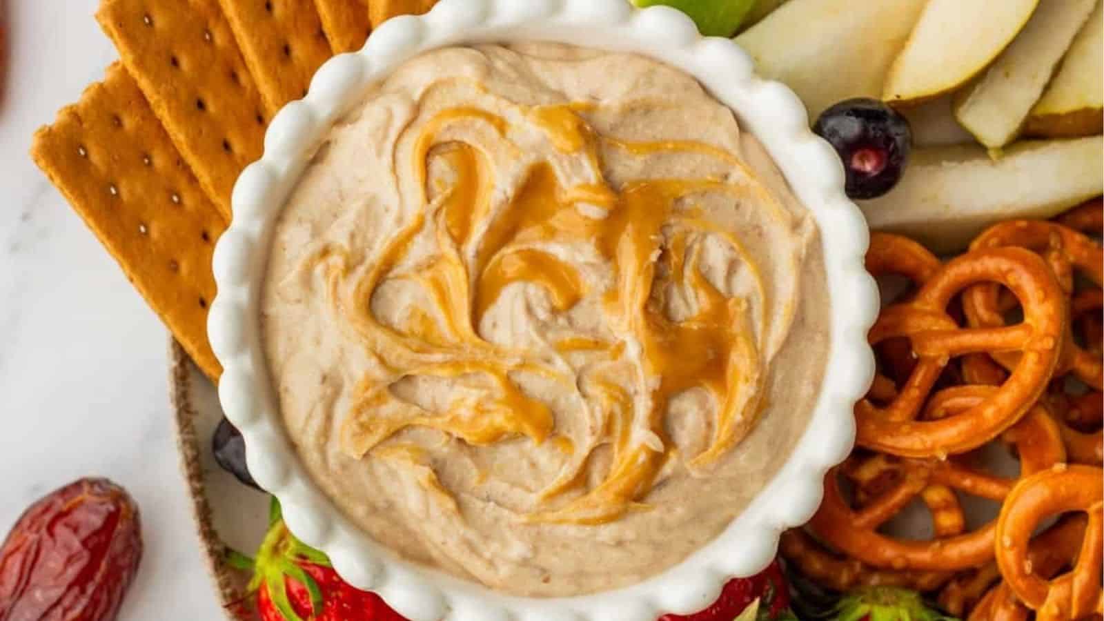 An overhead image of the caramel dip with crackers, pretzels, and sliced apples arranged around it.