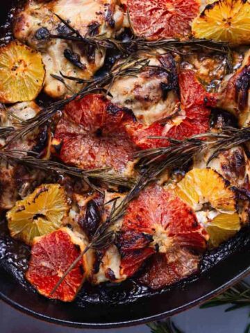 An overview of Creamy Citrus Chicken With Rosemary with slices of fresh citrus fruits around.