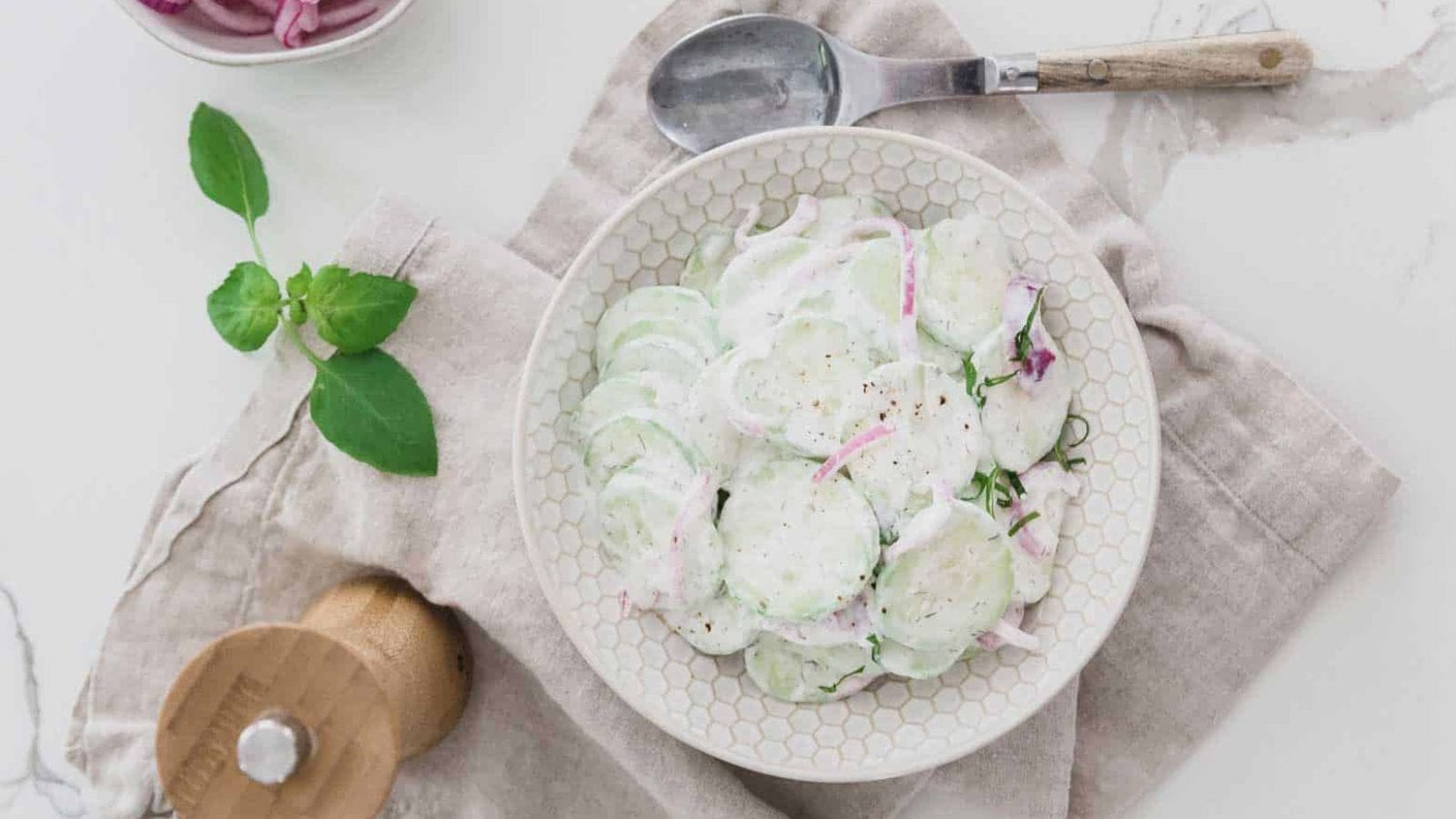 Top view of a plate with Creamy Cucumber Salad with Pickled Red Onions.