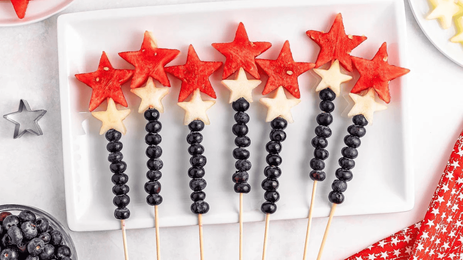 Watermelon Blueberry Sparklers lined up on a white plate.
