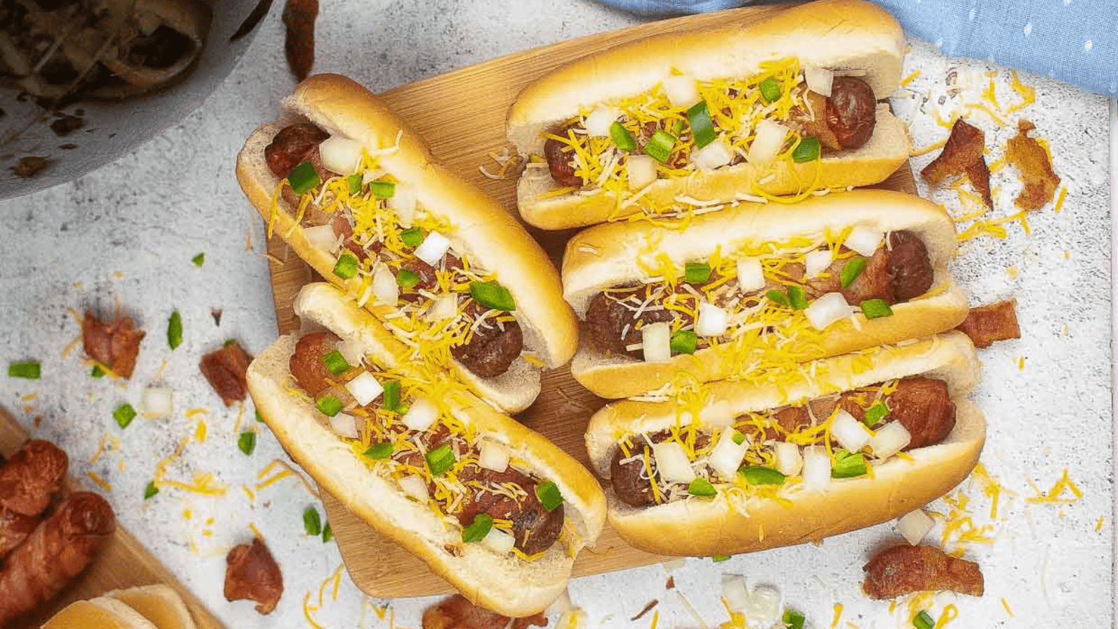 Air Fryer Bacon-wrapped Hot Dogs on a wooden board.