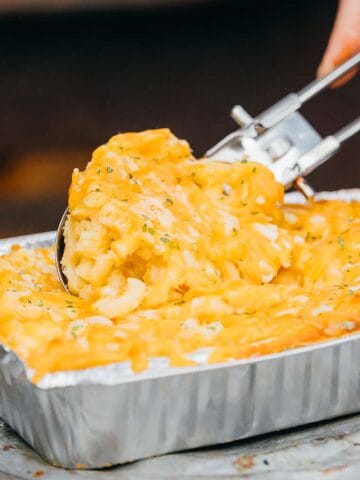 Someone scooping mac and cheese.